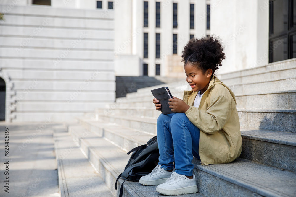 Smiling girl using digital tablet on steps Smiling girl using digital tablet on steps