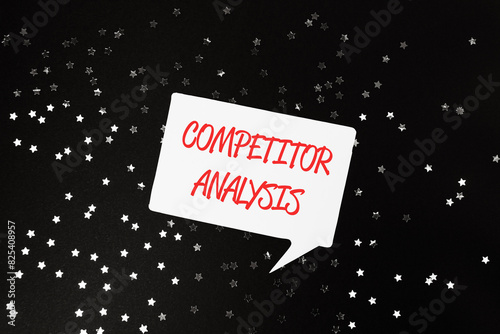A white sign with red letters that says Competitor Analysis