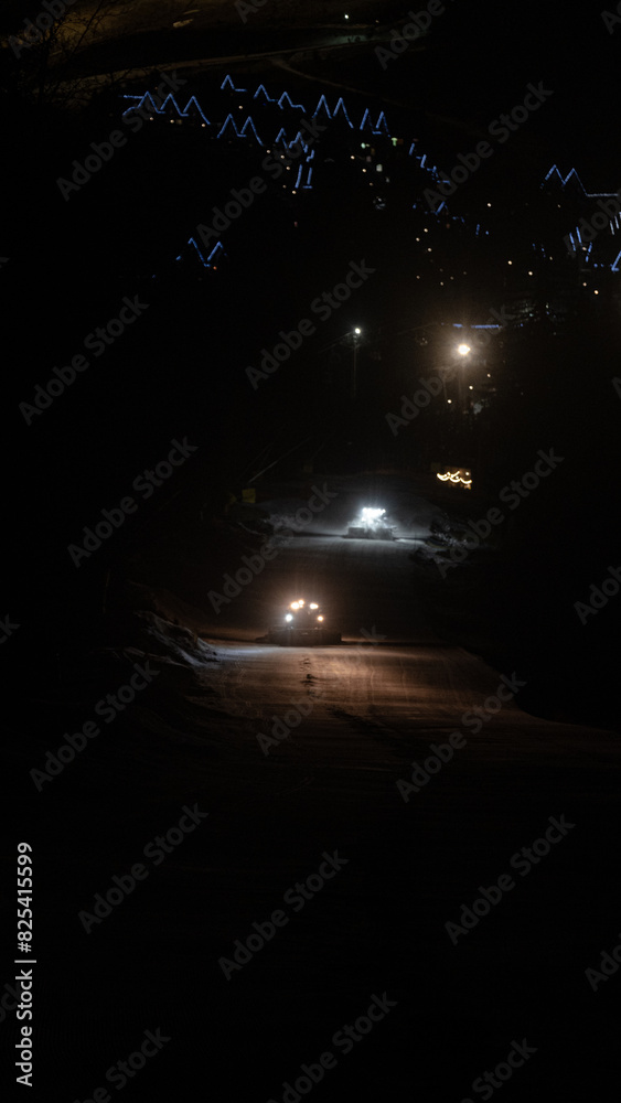 Snow-groomers work in nighttime on ski resort. Snow-groomers work in nighttime on ski resort.