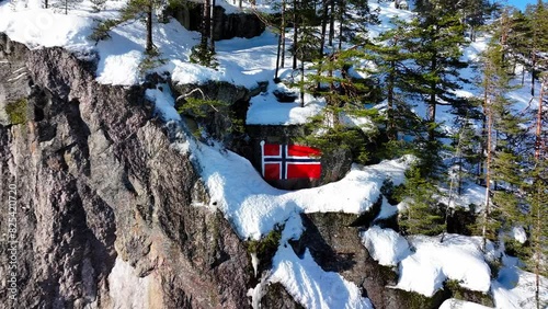 Drone pullout revealing Norwegian flag in snow-covered mountain hillside of Etnedal, Oppland, Norway photo