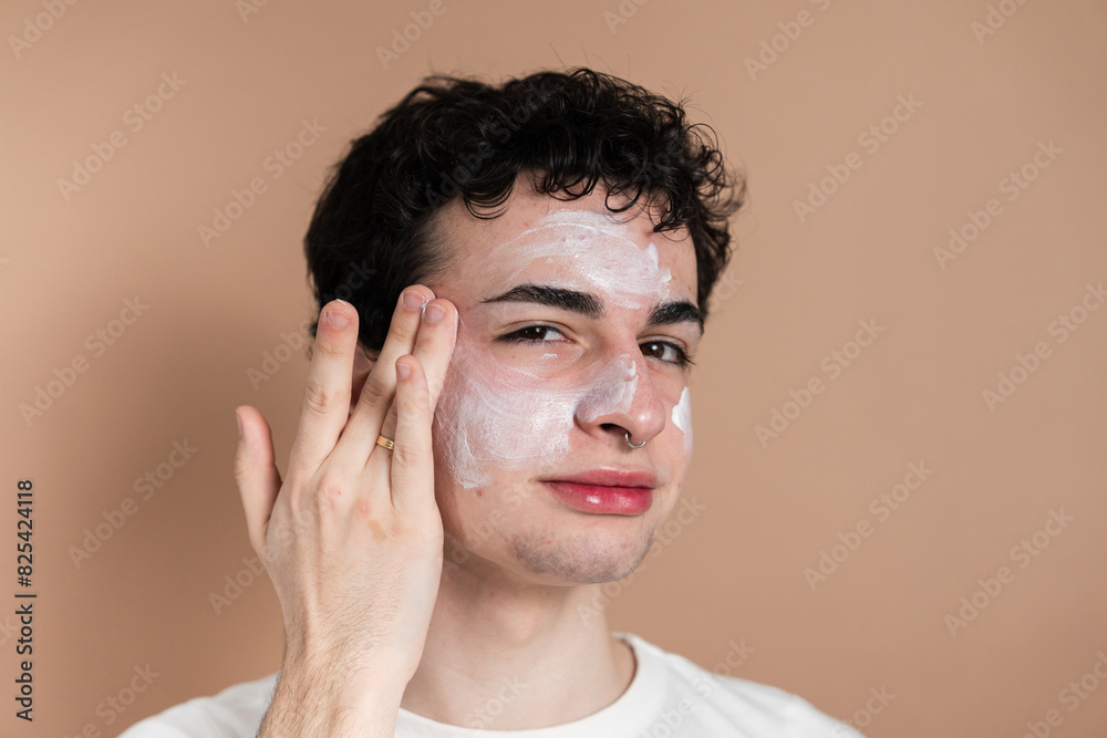 Young man applying facial cream Young man applying facial cream