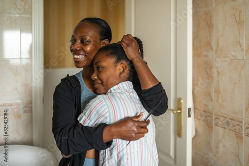 black mother with daughter in bathroom at home photo
