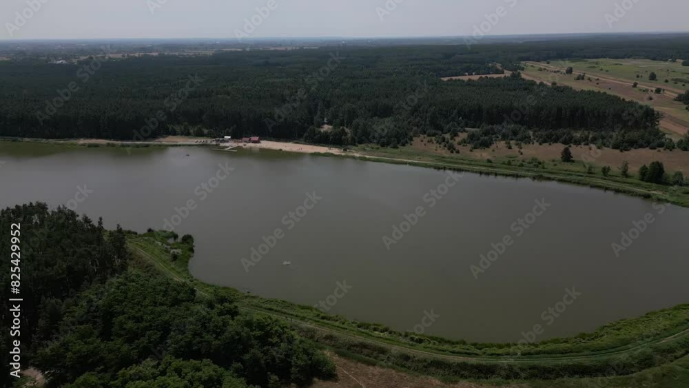 Aerial view of water reservoir among the dense green forest and rural fields on a sunny day, Poland Aerial view of water reservoir among the dense green forest and rural fields on a sunny day, Poland
