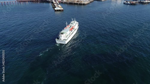 A passenger oil industrial vessel approaches the overpass on the oil rocks