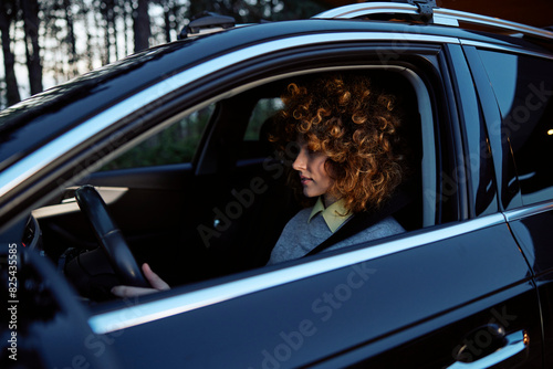 Portrait of a beautiful woman sits in the car photo