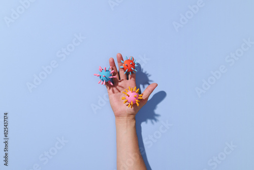 Paper cutout of dirty hand with virus on blue pastel background photo