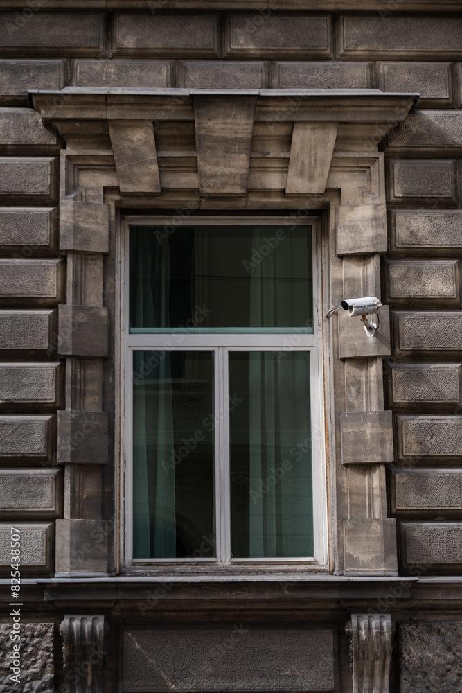 Window in old city center with camera. Window in old city center with camera.