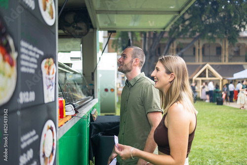 Couple ordering at a food truck at an outdoor market