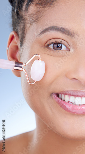 Dermatology roller, portrait and skincare with black woman in studio on blue background for wellness. Beauty, face and massage with confident model at spa for aesthetic or cosmetic skincare treatment