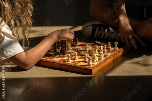 A chess board on the floor with a golden light perking through.