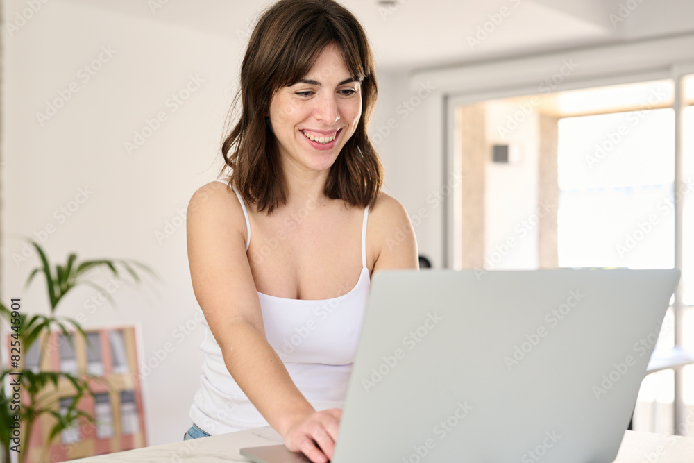 Woman smiles using laptop at home Woman smiles using laptop at home