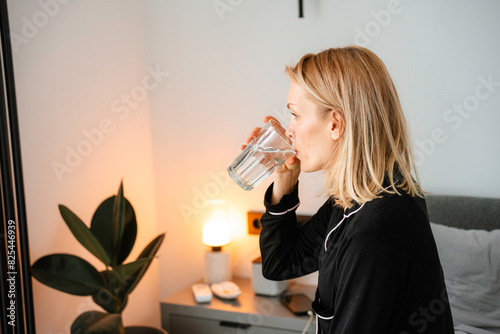 A woman drinks water in the morning photo