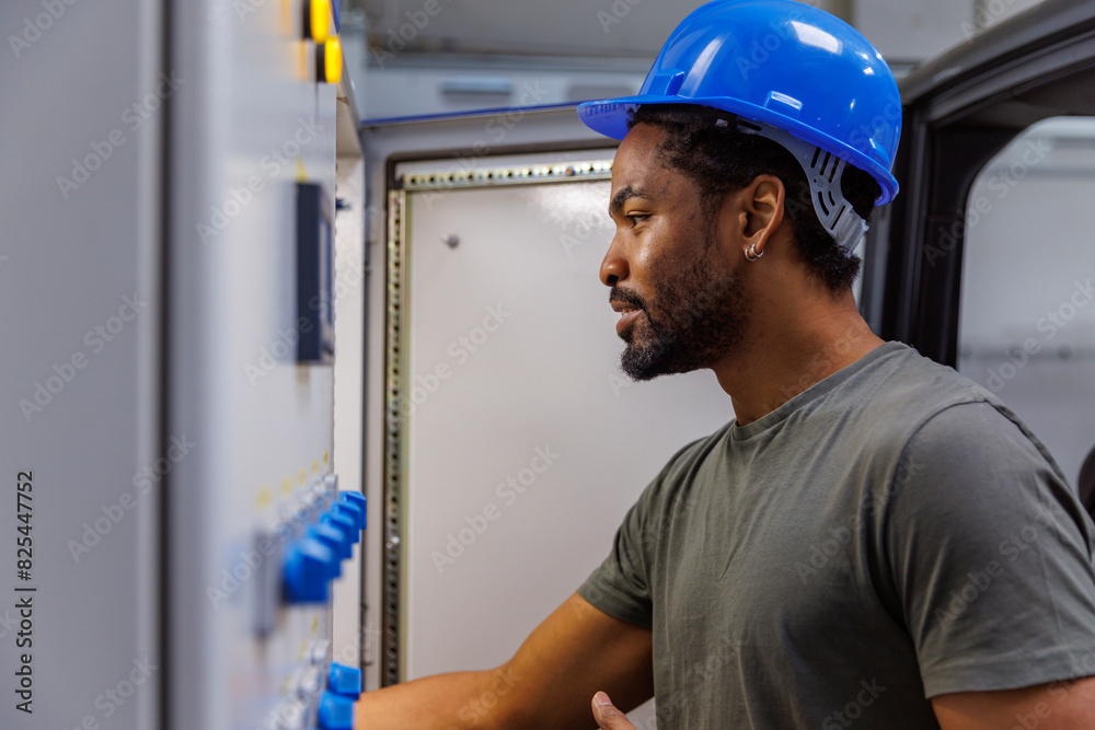 Worker in hardhat using machinery in industry Worker in hardhat using machinery in industry