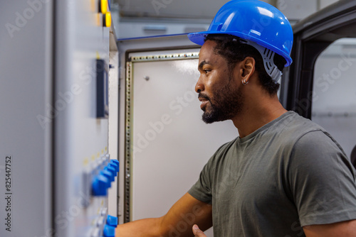 Worker in hardhat using machinery in industry photo