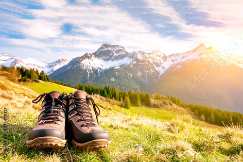 Wanderschuhe im Hintergrund eine Berglandschaft im Sonnenlicht 