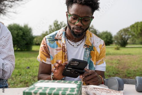 man typing on his cell phone in the park photo