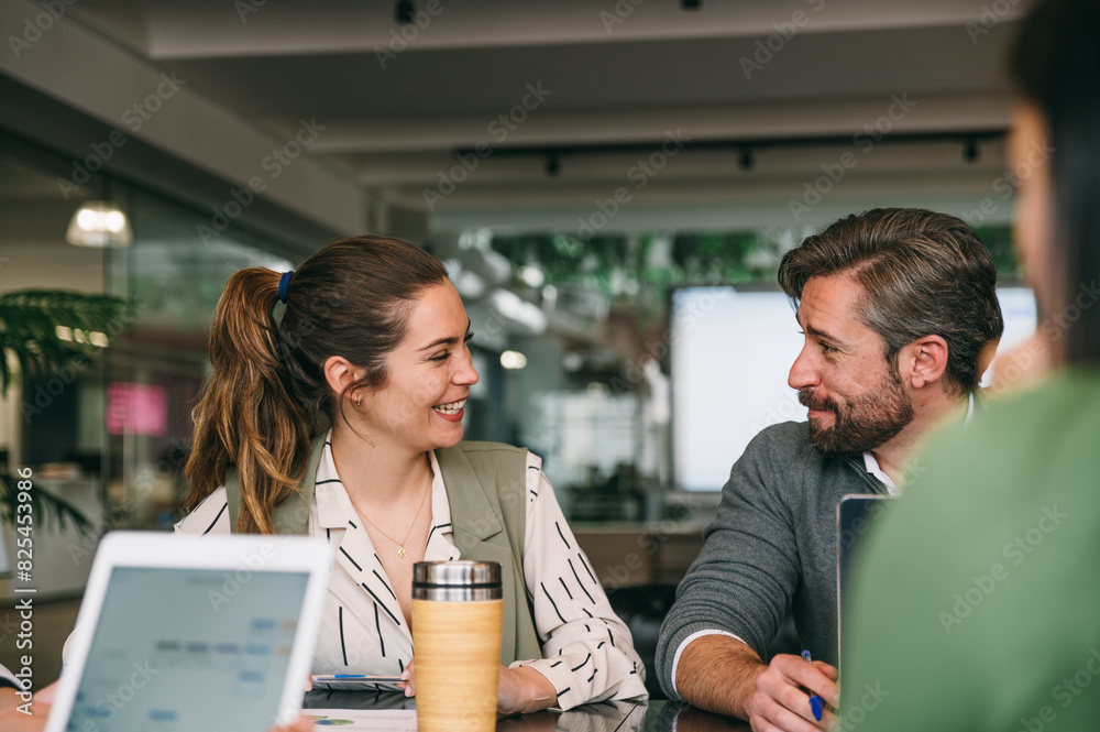 Colleagues engaged in a cheerful conversation at work Colleagues engaged in a cheerful conversation at work