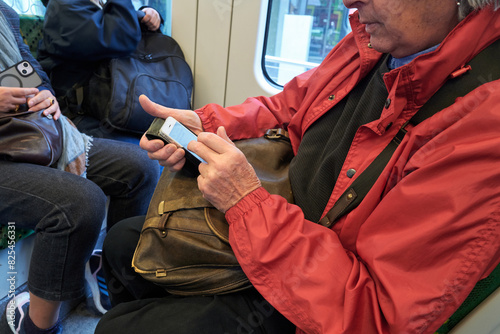 Senior person texting whilst travelling on tram in Melbourne  photo