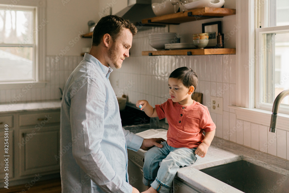 father brushing toddler's son teeth father brushing toddler's son teeth