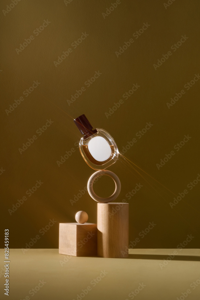 A perfume bottle on wooden podiums against brown background.