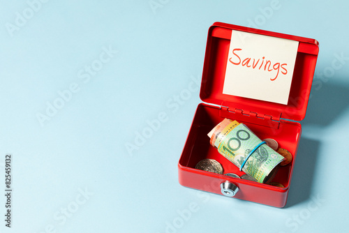 A 100 Australian dollar bill rolled inside a red box