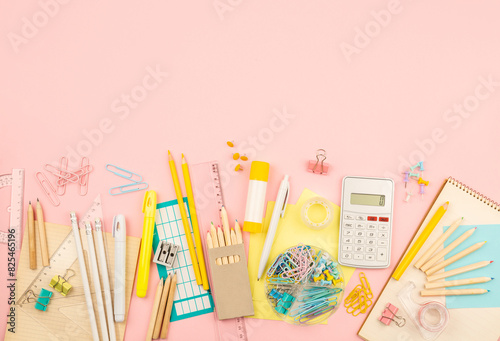 stationery items for girls or women on light pink background. Back to school. Female Student's, pupil's or engineer's supplies. Office objects on pastel pink background. Calculator, pen, pencil etc.