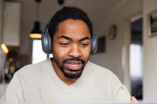 Man in headphones video calling at home photo
