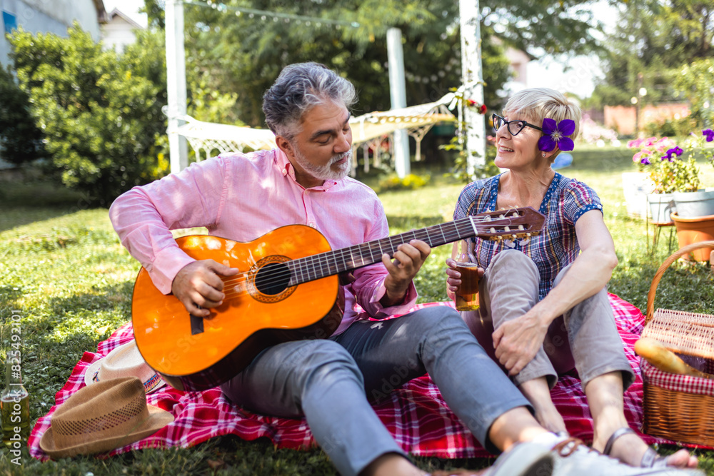 Loving mature couple with guitar in park Loving mature couple with guitar in park