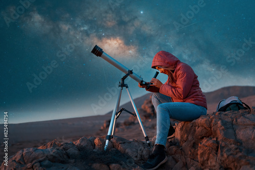 woman looking through the telescope observing the night sky in the desert	