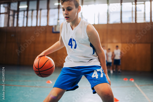 Foto A junior basketball player in action dribbling a ball on training