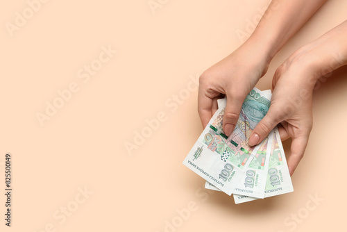 Female hands holding Bulgarian lev banknotes on beige background photo