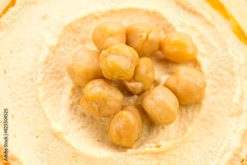 Hummus with dripping olive oil background, hummus texture close-up, rotation backdrop. Healthy vegan food. Top view