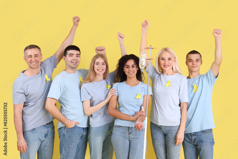Obraz premium Young woman undergoing chemical therapy course and people with yellow awareness ribbons on color background. World Cancer Day