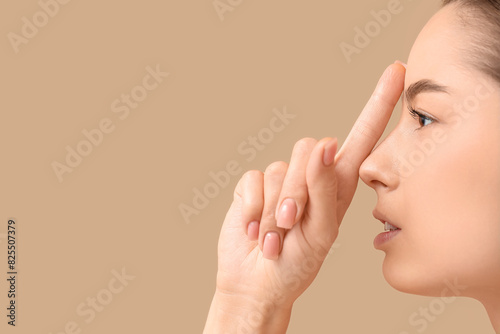 Young woman touching her no...