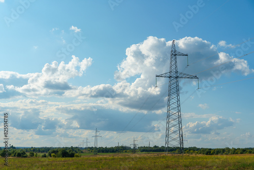 Power lines in an agricultural field. The support of an overhead power line in a wheat field against the background of clouds.