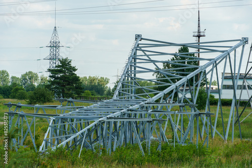 A broken power line pole lies in a field after a hurricane. Overhead power line support during repair.