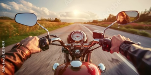 Biker on a motorcycle rides along a scenic road at sunset