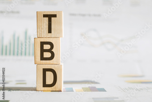 Businesswoman made word tbd with wood building blocks.