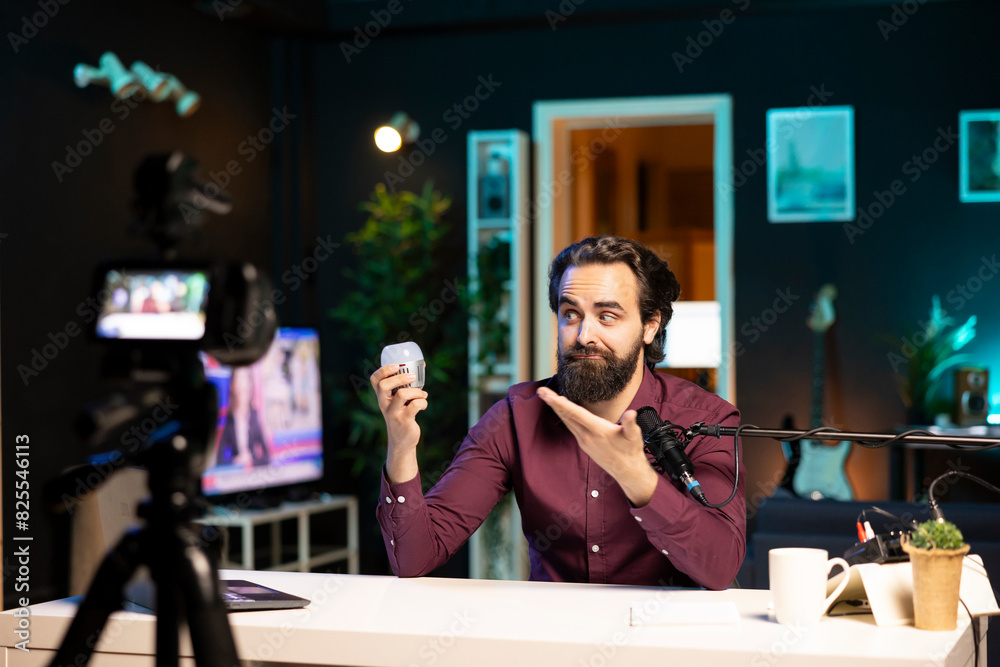 Tech expert looking at defective smart light bulb, trying to repair it while filming. Internet star hosting technology show, fixing broken IoT home automation product in neon lit studio Tech expert looking at defective smart light bulb, trying to repair it while filming. Internet star hosting technology show, fixing broken IoT home automation product in neon lit studio