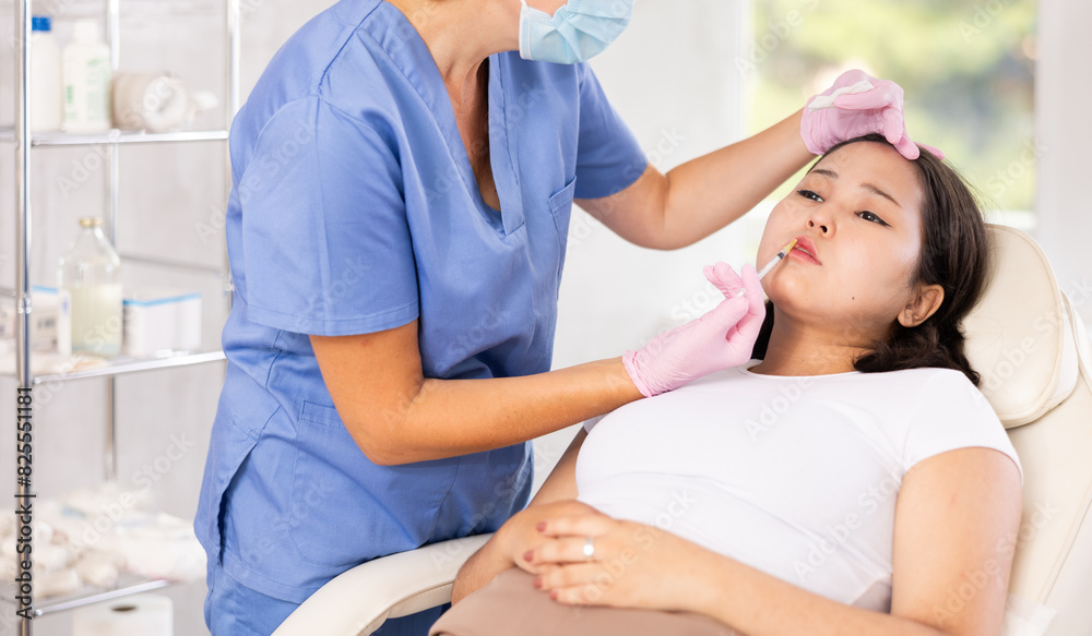 Fototapeta premium Woman getting facial beauty treatment by professional medicine worker in medical center