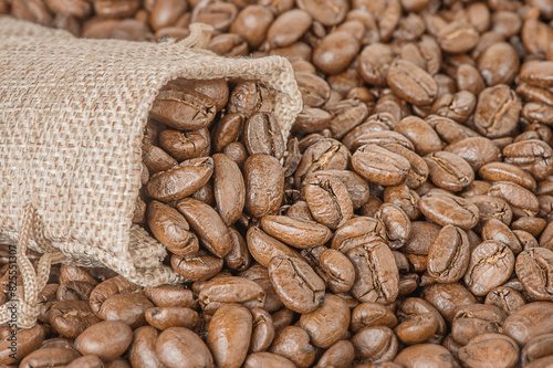 Roasted coffee beans as a background. Coffee in a bag. © Lesia
