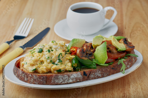 Sourdough bread with scrambled eggs,avocado mushrooms and tomatoes. photo