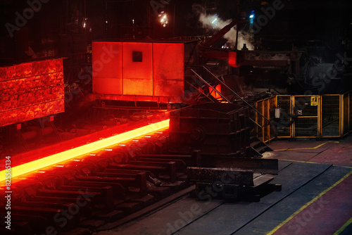 Rolled metal factory. Hot iron slab moving on conveyor of metal rolling mill