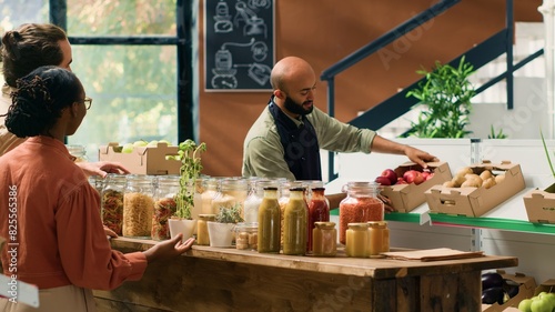 Couple shopping for organic produce in eco local supermarket, supporting small business owner and farmer. People looking to buy chemicals and additives free food or pantry supplies, vegan life.