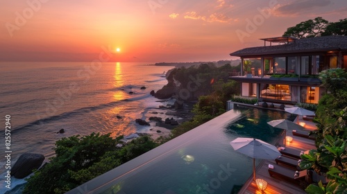 Spectacular sunset view of luxury clifftop villa overlooking the ocean with infinity pool, lush greenery, and serene atmosphere in tropical paradise photo