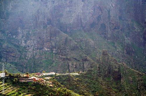 A scenery landscape with the rocky mountains and a village in Masca Gorge of Tenerife at sunset. photo