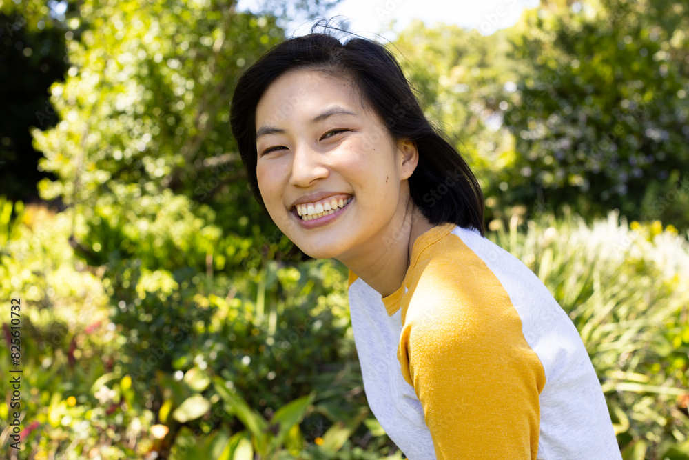 Asian young woman smiling, wearing yellow top outdoors Asian young woman smiling, wearing yellow top outdoors