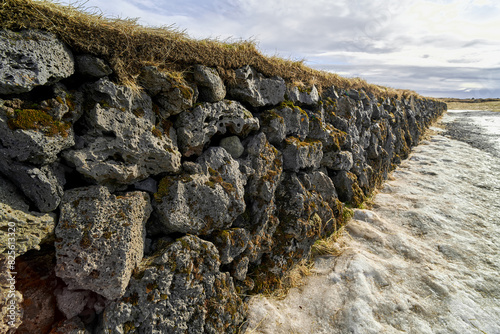 Stone wall with moss and snow