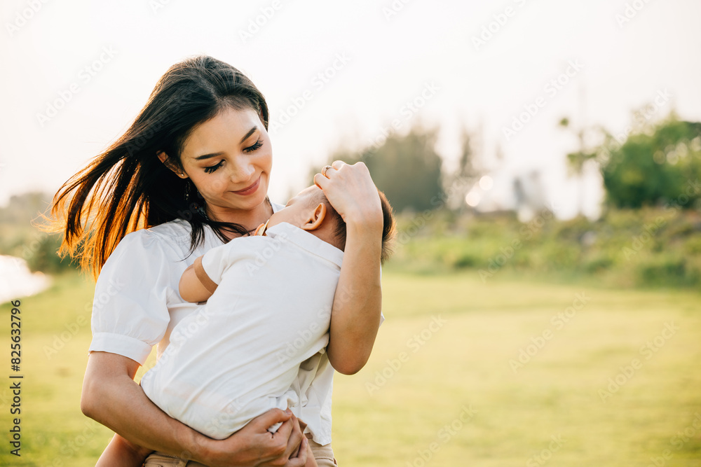 Family care. Happy beautiful mother holding baby sleeping son in the park at evening time before sunset, Portrait of mom hold newborn feeling happy and smiles in the garden nature outdoor, Mother Day Family care. Happy beautiful mother holding baby sleeping son in the park at evening time before sunset, Portrait of mom hold newborn feeling happy and smiles in the garden nature outdoor, Mother Day