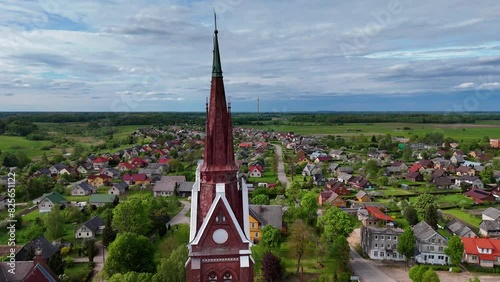 Sveksna church towers and village in lithuania, surrounded by green fields, aerial view photo